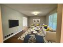 Bright living room with hardwood floors, modern sofa and white coffee tables at 4550 Cypress Ridge Ct, Stone Mountain, GA 30083