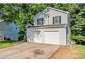 Exterior view of a two-story home showcasing a two-car garage and well-maintained siding at 7021 New Dale Rd, Rex, GA 30273