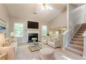 Bright living room with vaulted ceilings, fireplace, and plush neutral furnishings at 7021 New Dale Rd, Rex, GA 30273