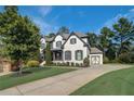 Gorgeous two-story home showcasing a lush green lawn, driveway, and painted brick exterior with dark shutters at 2295 Abbey Cove Ct, Marietta, GA 30062