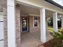 View of the brick front porch showing pillars and a glass front door at 6945 Melody Ridge Rd, Buford, GA 30518