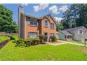 Beautiful two-story brick home with a well-manicured lawn and lush landscaping for great curb appeal at 711 Ashley Ln, Stone Mountain, GA 30087