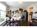 Bright dining room with unique wall art, a large window and dark wood floors with kitchen view at 7270 Williamsburg Dr, Riverdale, GA 30274