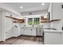 Well-lit kitchen featuring stainless steel appliances, white cabinetry, wood shelves and sleek wood floors at 2550 Laurel Ridge Dr, Decatur, GA 30033