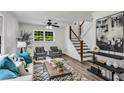Bright living room featuring neutral walls and wood floors, modern furniture, and a staircase with a wood railing at 2550 Laurel Ridge Dr, Decatur, GA 30033