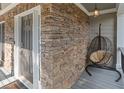 Charming stone porch with a hanging chair and a stylish front door with sidelights at 428 Gold Xing, Canton, GA 30114