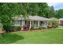 Charming single-story home featuring a well-manicured lawn and inviting front porch with a cheerful blue door at 963 Turner Se Dr, Smyrna, GA 30080