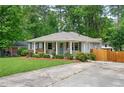 Charming single-story home featuring a well-manicured lawn and inviting front porch with a cheerful blue door at 963 Turner Se Dr, Smyrna, GA 30080
