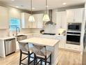 Bright kitchen with white cabinets, stainless steel appliances, quartz countertops, and an island at 306 Coppergate Ct, Canton, GA 30115