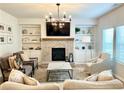 Comfortable living room with a brick fireplace, built-in shelving, and natural light from the windows at 306 Coppergate Ct, Canton, GA 30115