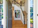 View of foyer with an open doorway, staircase, and decorative wall art at 560 Edgehill Pl, Johns Creek, GA 30022