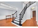 Elegant staircase with black railings and white trim in a home with hardwood floors at 5735 Lake Windsor Pkwy, Buford, GA 30518