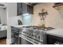 Gourmet kitchen featuring stainless steel gas range, marble counters, and modern backsplash at 328 Brownstones Cir, Atlanta, GA 30312