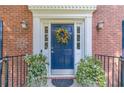 Close up of a beautiful front door with a decorative wreath and potted plants at 4105 Vicksburg Dr, Lawrenceville, GA 30044