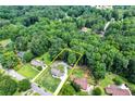 Aerial view showcases a tree-surrounded property with a charming home and expansive yard at 175 Hunters Gln, Fayetteville, GA 30215