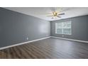 Bright, empty living room featuring wood floors, neutral paint, and a ceiling fan at 3303 Par Three Way, Lithonia, GA 30038