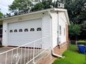 Close-up of a white garage with decorative windows and a brick foundation, showcasing side access at 3769 Amber Nw Rd, Atlanta, GA 30331