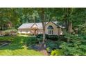 Charming one-story home with a well-manicured lawn, lush greenery, and mature trees at 1565 Kings Xing, Smoke Rise, GA 30087