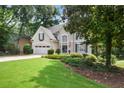 Beautifully landscaped front yard and exterior of a charming two-story home, featuring an attached garage at 6380 Bannerhorn Run, Alpharetta, GA 30005