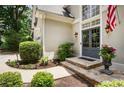 Stone steps lead to double front door entrance, surrounded by manicured landscaping at 6380 Bannerhorn Run, Alpharetta, GA 30005