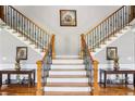 Elegant foyer showcasing a grand staircase with decorative wrought iron spindles and hardwood floors at 2631 Young Rd, Stone Mountain, GA 30088