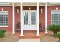 Inviting front entrance with double doors, brick columns, and decorative plants at 2631 Young Rd, Stone Mountain, GA 30088