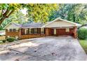 Charming brick home features a covered carport and an expansive driveway at 516 Jordan Nw Dr, Tucker, GA 30084