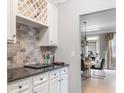 Home wet bar with wine rack, subway tile backsplash, and dark countertops at 5290 Hidden Valley Ln, Cumming, GA 30028