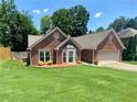 Charming one-story brick home featuring a manicured lawn, bay window, and attached two-car garage at 5022 Anclote Dr, Alpharetta, GA 30022