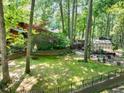 Serene backyard featuring a greenhouse, lush greenery, and private wooded views at 686 Hillwood Ct, Dacula, GA 30019