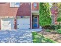 Close up on a brick house exterior with a blue door and two-car garage, showcasing its charming facade at 1668 Legrand Cir, Lawrenceville, GA 30043