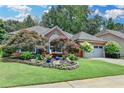Beautiful brick home featuring mature trees, a well-kept lawn, and an attached two-car garage at 510 Elgaen Ct, Roswell, GA 30075