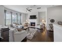 Bright living room with fireplace, ceiling fan, hardwood floors and comfortable seating creating a cozy atmosphere at 5504 Cameron Parc Dr, Alpharetta, GA 30022