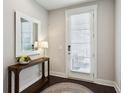 Inviting foyer with stylish console table, mirror, and door with privacy blinds at 704 Banton Nw Dr, Atlanta, GA 30318