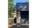 Garage exterior featuring stone and painted siding at 9025 Huntcliff Trce, Atlanta, GA 30350