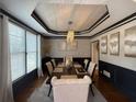Elegant dining room with modern chandelier, decorative molding, and large windows for natural light at 998 Poplar Mill Ct, Buford, GA 30518