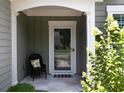 Charming front porch area with a decorative chair, stone flooring, and lush landscaping at 2871 Goldfinch Cir, Marietta, GA 30066
