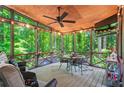Inviting screened porch with wood ceiling, fan, and view of the backyard's trees at 4686 Buckskin Sw Trl, Lilburn, GA 30047