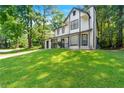 Side view of this charming two-story home with black trim and lush lawn at 534 Woodcrest Manor Dr, Stone Mountain, GA 30083
