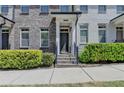 Close-up of a townhome entrance with brick steps and manicured shrubs at 3879 Glenview Club Ln, Duluth, GA 30097