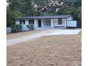 A ranch-style home with a freshly paved driveway, white exterior, and black trim at 559 Allgood Rd, Stone Mountain, GA 30083