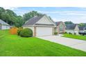 Exterior view of a single-story home with attached garage and verdant lawn at 1890 Owens Trl, Rex, GA 30273
