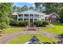 Stately two-story brick home with white columns and a circular driveway featuring a charming water fountain at 1961 Luke Edwards Rd, Dacula, GA 30019