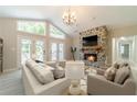 Inviting living room with a stone fireplace, light gray walls, and french doors to the outside at 4120 Grady Smith Rd, Loganville, GA 30052