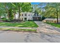 Inviting white-brick home featuring a lush green lawn and a driveway leading to a two-car garage at 4385 Pinehollow Court Ct, Alpharetta, GA 30022