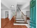 Bright entryway featuring a hardwood floor, white walls, and an open staircase leading to the second floor at 1410 Kingfield Dr, Johns Creek, GA 30005
