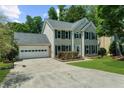 Traditional two-story home boasts a lush front lawn and an attached two-car garage, perfect for Gathering living at 1410 Kingfield Dr, Johns Creek, GA 30005