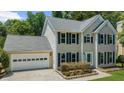 Inviting two-story home featuring a spacious front yard and a convenient attached two-car garage at 1410 Kingfield Dr, Johns Creek, GA 30005