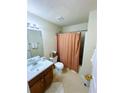 Cozy bathroom featuring a shower with an orange patterned curtain and neutral-toned decor at 7104 Georges Way, Morrow, GA 30260