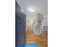 Inviting entryway with hardwood floors, staircase, and a view into the living spaces at 5176 Shotwell St, Woodstock, GA 30188